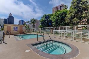 a hot tub on a patio with a city in the background at A Corner Unit with OCEAN VIEWS from EVERY ROOM in Long Beach