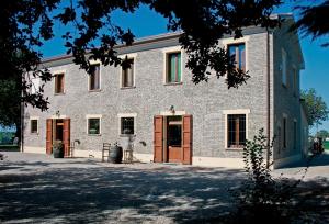 a large brick building with brown doors and windows at La Spagnera in San Pietro in Vincoli