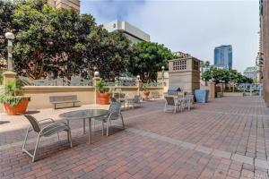 een patio met tafels en stoelen op een bakstenen stoep bij A Corner Unit with OCEAN VIEWS from EVERY ROOM in Long Beach