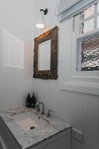 a bathroom with a sink and a mirror on the wall at Mopsy's On The Esplanade in Wagga Wagga