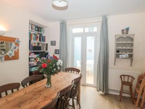 a dining room with a wooden table with flowers on it at Dunholme House in Teignmouth