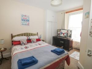 sypialnia z łóżkiem z niebieskimi ręcznikami w obiekcie Dunholme House w mieście Teignmouth