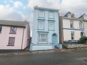 a blue house and two white houses on a street at Dunholme House in Teignmouth