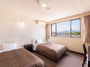 Postel nebo postele na pokoji v ubytování Hotel Primrose Saito