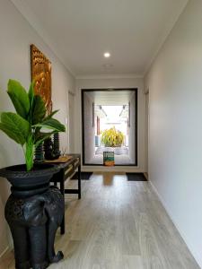ein Flur mit einem Tisch und einer Topfpflanze in der Unterkunft Bali Elliott Heads - Coastal Holiday Home near Boat Ramp in Elliott Heads