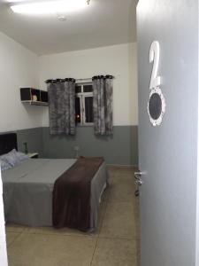 a bedroom with a bed and a door with the number two at Hostel Lize in Cumbica