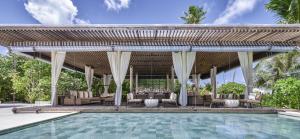 a pavilion with chairs and a swimming pool at Park Hyatt Maldives Hadahaa in Gaafu Alifu Atoll
