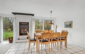 uma sala de jantar com uma mesa e cadeiras e uma lareira em Pet Friendly Home In Spttrup With House A Panoramic View em Spottrup