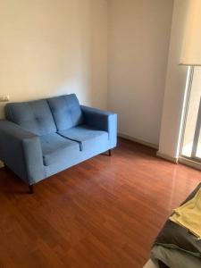 a blue couch in a living room with a wooden floor at Departamento Tipo Estudio / 1 Ambiente in Santiago