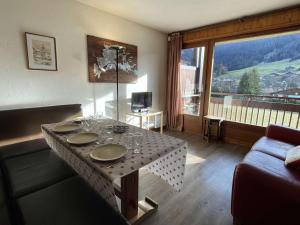 a living room with a table with wine glasses on it at Charmant 2P cabine 35m², proche pistes et village, parking, 4 pers. - FR-1-603-71 in Praz-sur-Arly