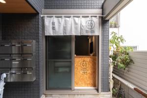 una puerta delantera de una casa con un cartel en ella en 5963 Hotel Higashi Ikebukuro, en Tokio