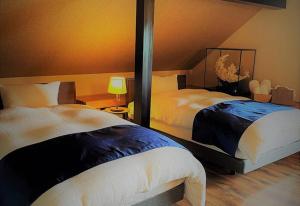 a bedroom with two beds and a lamp in it at 絶景を眼下に見渡す 天空のお宿 雅館 in Ichinoseki