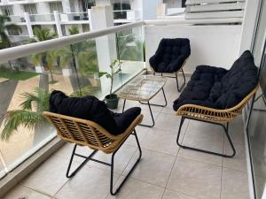 three chairs sitting on top of a balcony at Elegante y espacioso Apartamento en Playa Blanca in Río Hato +1 photo