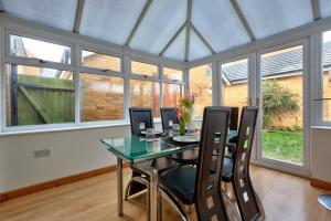 a dining room with a glass table and chairs at Free Parking - Large House - Contractor - Leisure in Peterborough