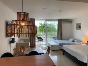 a living room with a room with a bed and a table at Elegante y espacioso Apartamento en Playa Blanca in Río Hato