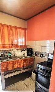 uma cozinha com um lavatório e um fogão em Starfish Cahuita's House - Casa Vacacional em Cahuita