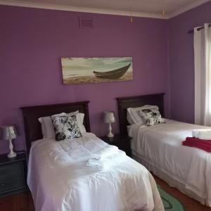 a bedroom with two beds and a boat on the wall at Guest house Winklespruit in Kingsborough