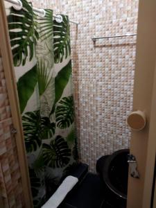 baño con aseo negro y planta en Quarto tranquilo a 7 minutos do Pelourinho, en Salvador