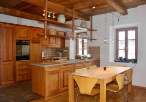 eine Küche mit Holzschränken und einem Holztisch in der Unterkunft Ferienwohnung Scaletta in Scuol