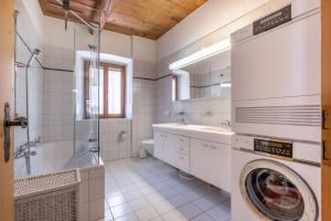 ein weißes Bad mit einer Waschmaschine in der Unterkunft Ferienwohnung Scaletta in Scuol