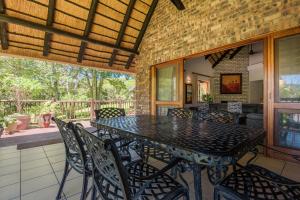 une salle à manger avec une table et des chaises sur une terrasse dans l'établissement Kruger Park Lodge Unit No. 241, à Hazyview