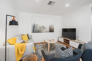 a living room with a couch and a tv at Villa on Valcross in Dunsborough