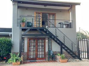 a house with a staircase leading up to a balcony at 22 on Mirabel in Kempton Park