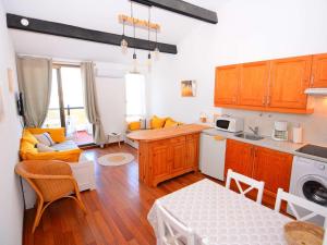 a kitchen with wooden cabinets and a table in a room at Appartement Le Barcarès, 2 pièces, 4 personnes - FR-1-431-181 in Le Barcarès