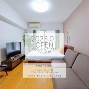 a room with a bed and a couch and a tv at Picoro Hakata - Vacation STAY 11333 in Fukuoka
