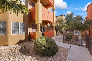 a building with a fence and a bush in front of it at Hawk Ridge Two Bedroom Condo by Cool Properties in Mesquite