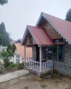 een klein bakstenen huis met een rood dak bij Snow White Holiday Inn Homestay in Kalimpong