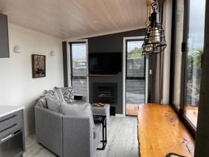 a living room with a couch and a tv at Pukeko Lane in Tauranga