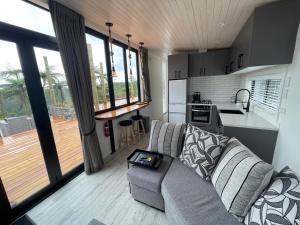 a living room with a couch and a kitchen at Pukeko Lane in Tauranga