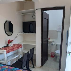 a room with a toilet and a table and chairs at B&B KeisyAlba Punta Rucia in Punta Rucia