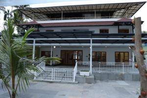 Casa blanca con porche y balcón en QUILON LAKE INN, en Kollam