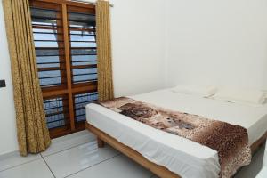 Postel nebo postele na pokoji v ubytování QUILON LAKE INN