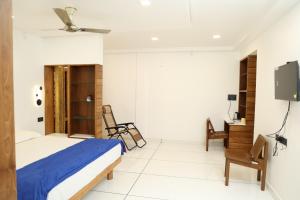 1 dormitorio con 1 cama, escritorio y TV en QUILON LAKE INN, en Kollam