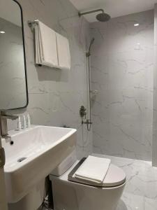 a white bathroom with a toilet and a sink at West Prime Hotel in Calbayog