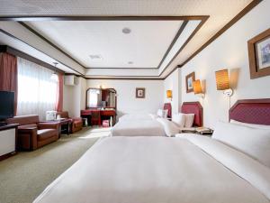 彰化市にあるGuide Hotel Changhua Jhongjhengのベッド2台とテレビが備わるホテルルームです。