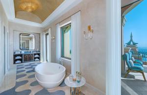 ein Bad mit einer großen weißen Badewanne in einem Zimmer in der Unterkunft Atlantis, The Palm in Dubai