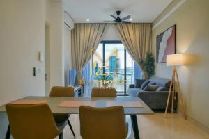 een woonkamer met een tafel en stoelen en een bank bij Maxhome Plus at Lucentia Bukit Bintang City centre KL in Kuala Lumpur