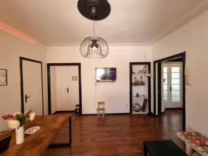 a living room with a table and a chandelier at Downtown Belgrade Hostel and Apartments in Belgrade