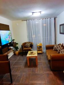 sala de estar con sofá, mesa y TV en Departamento full equipado, en La Serena