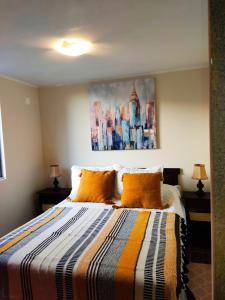 1 dormitorio con 1 cama y una pintura en la pared en Departamento full equipado, en La Serena