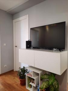 salon z telewizorem z płaskim ekranem w białym centrum rozrywki w obiekcie Sunshiny Costa del Sol - BEACH APARTMENT w mieście Fuengirola