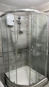 y baño con ducha y mampara de cristal. en Full floor in duplex apartment, en Avcılar