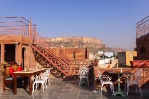 a patio with tables and chairs on a roof at Amritara Manak Haveli, Jodhpur in Jodhpur