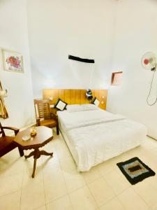 a bedroom with a large bed and a table at Hikka Paradise Guest House in Hikkaduwa