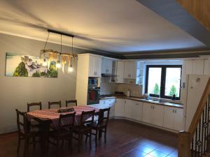 a kitchen with a table and chairs and a kitchen with a window at Willa Jagoda domek w górach in Zabrzeź