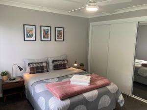 - une chambre avec un lit recouvert d'une couverture rose dans l'établissement Oleander Cottage, à Orange